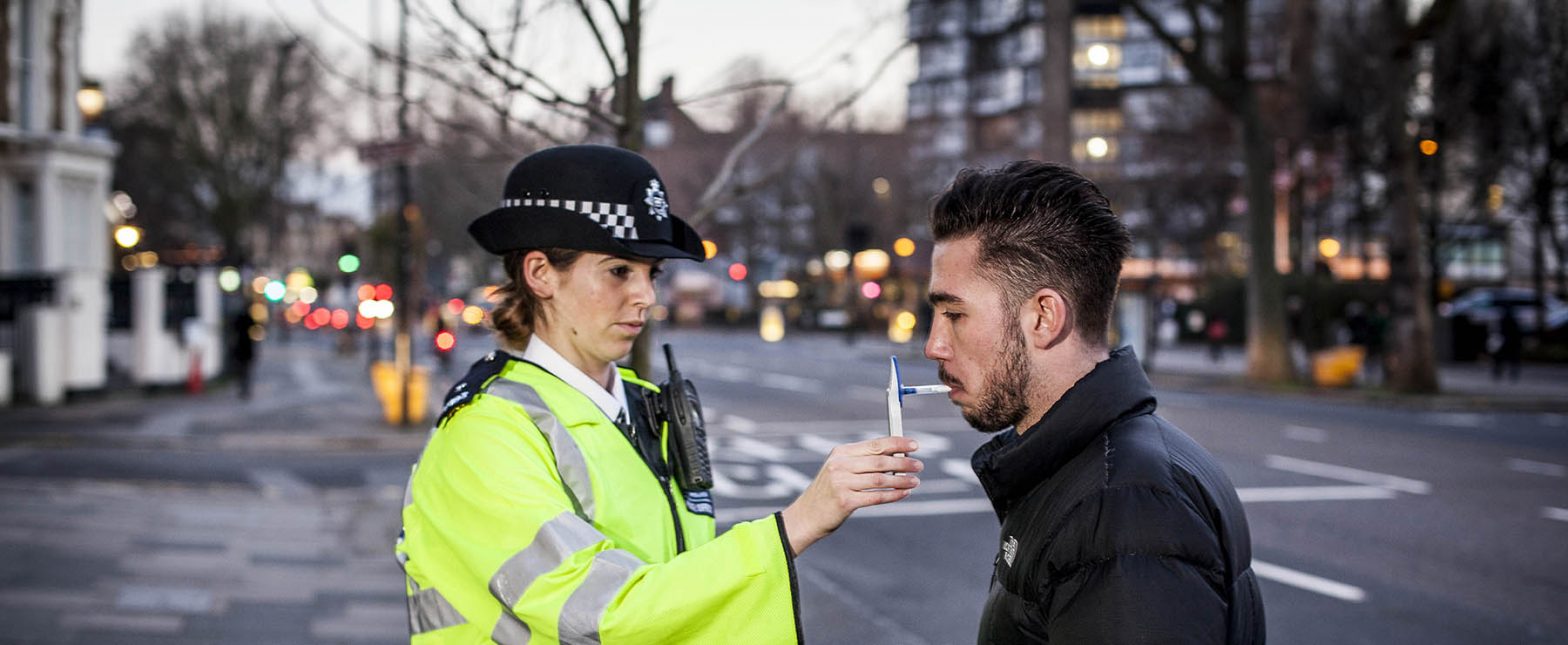 police officer breathalysing a male