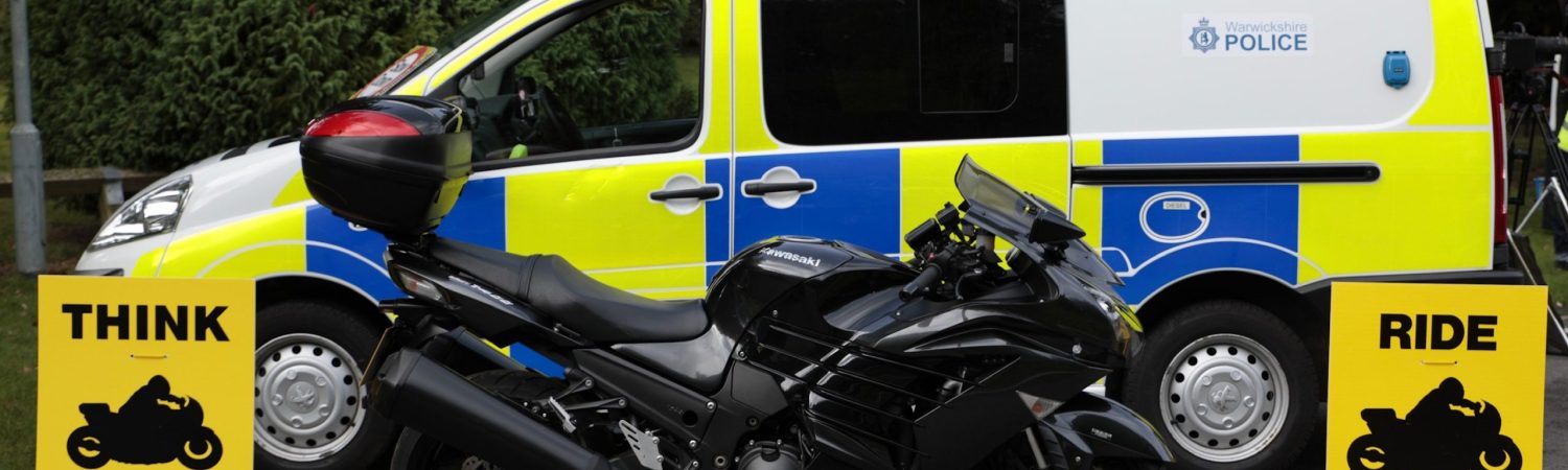 THINK BIKE signage with a police van and motorbike